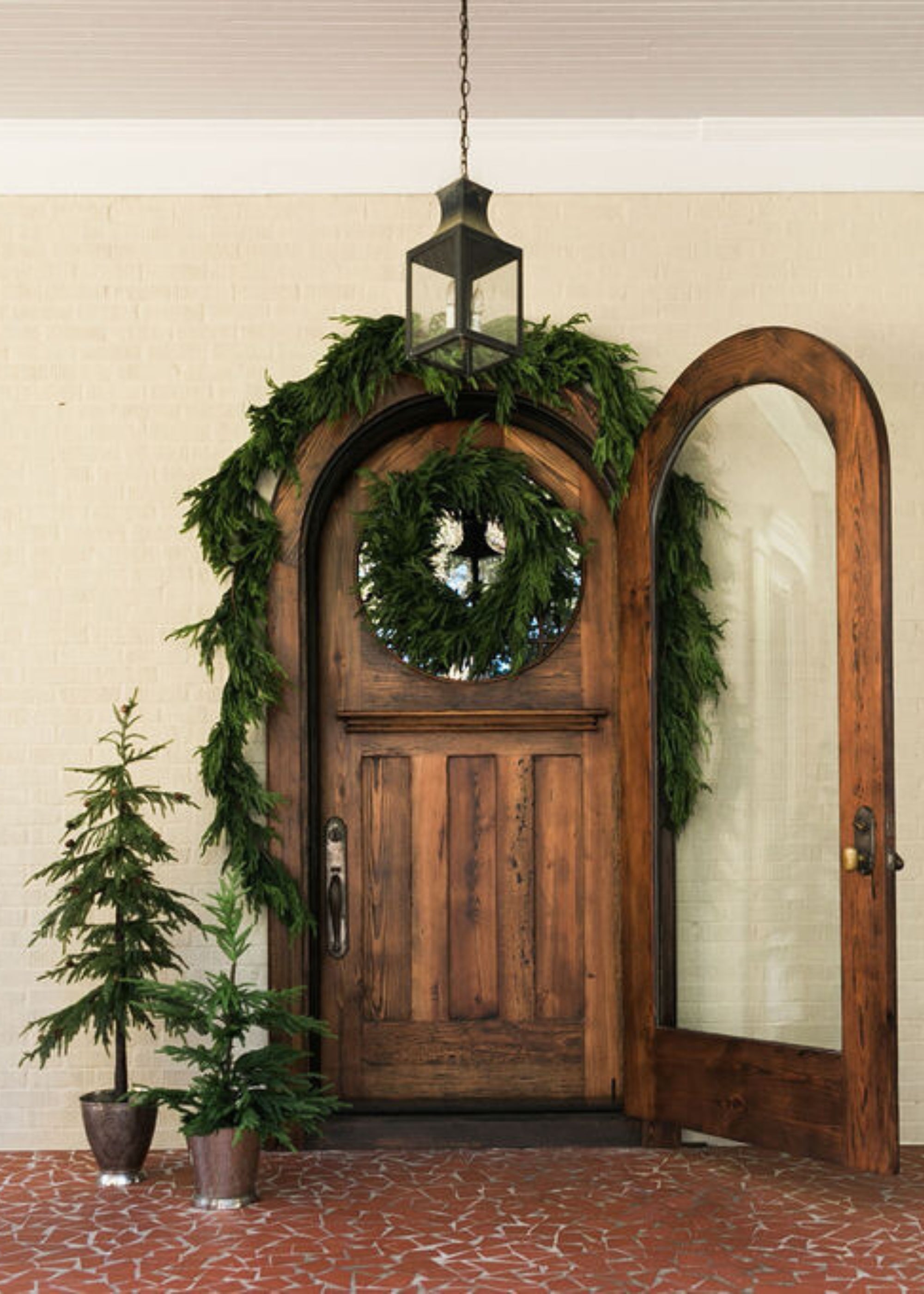Small faux Norfolk pine tree styled with seasonal greenery