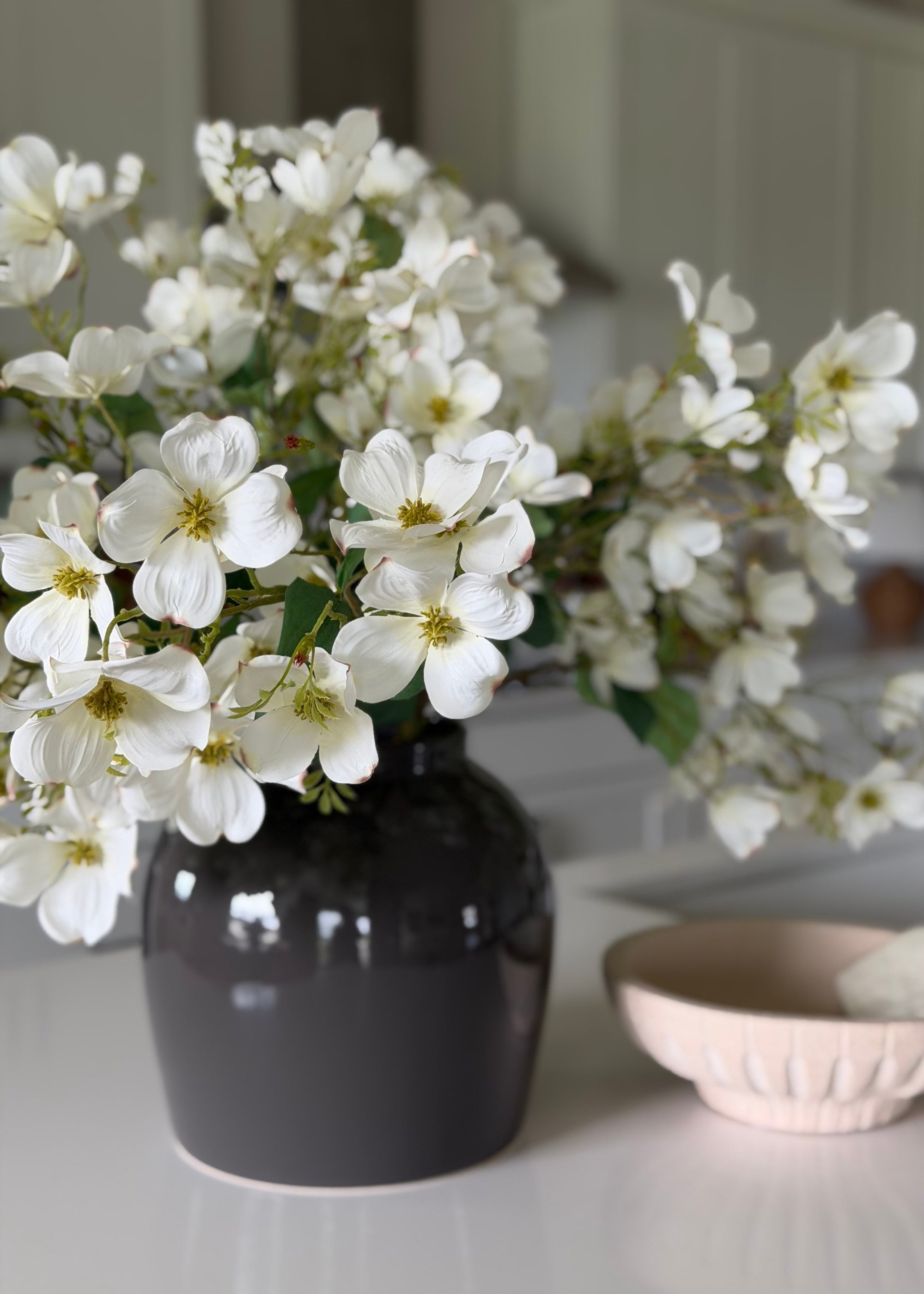 White blooming branch arranged in statement vase