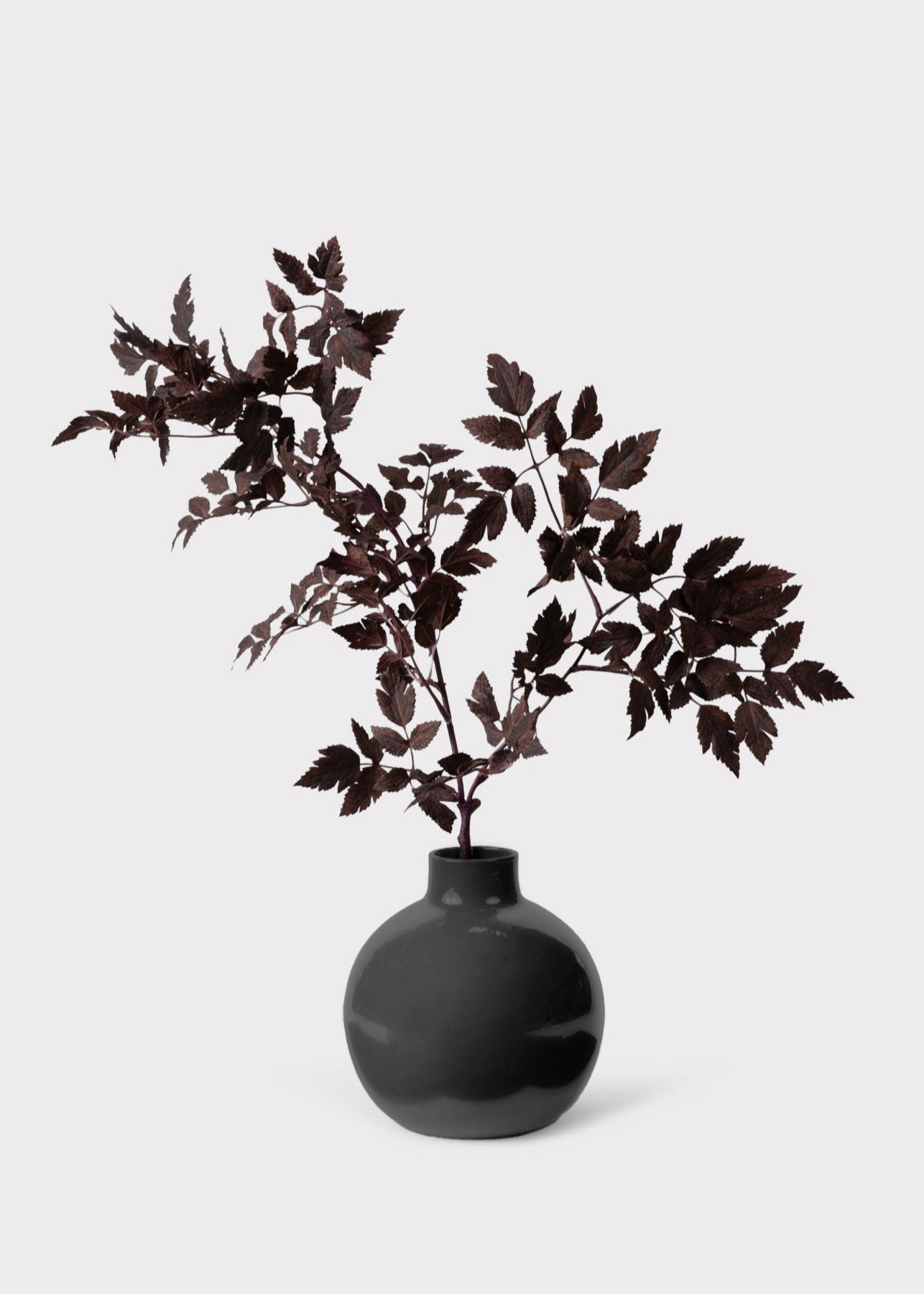 Small round vase styled with faux flowers for home decor